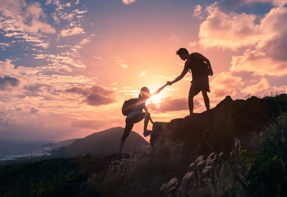 two hikers climbing upward together